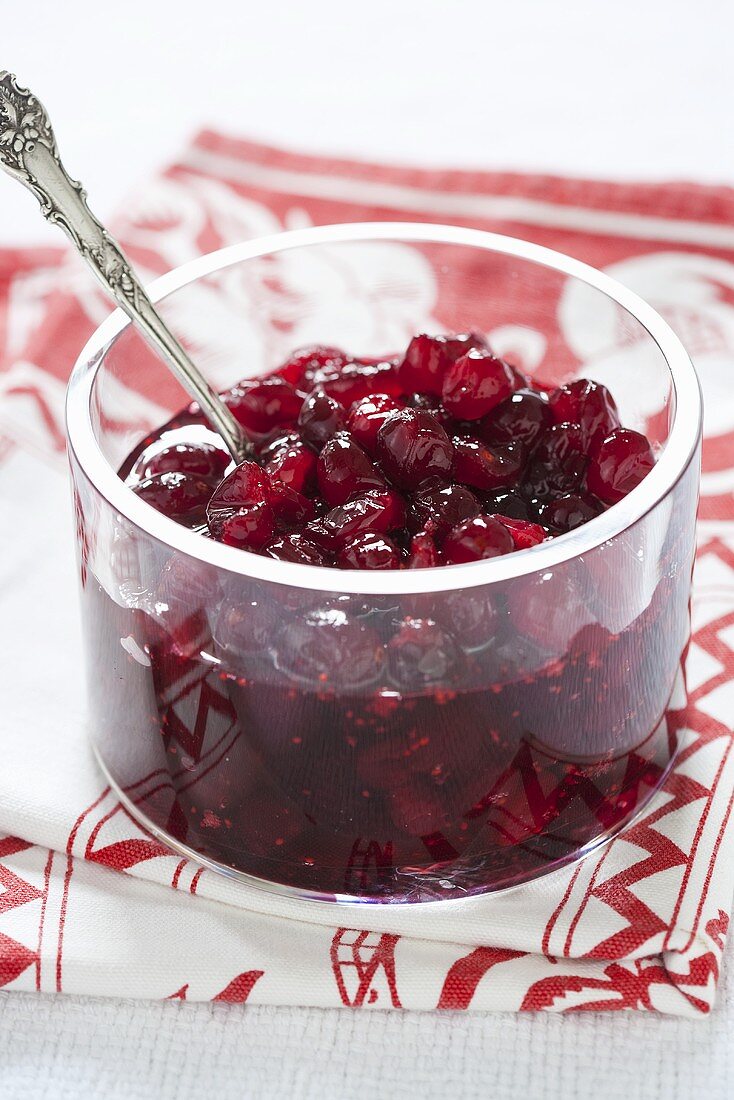 Cranberry sauce in glass dish on tea towel