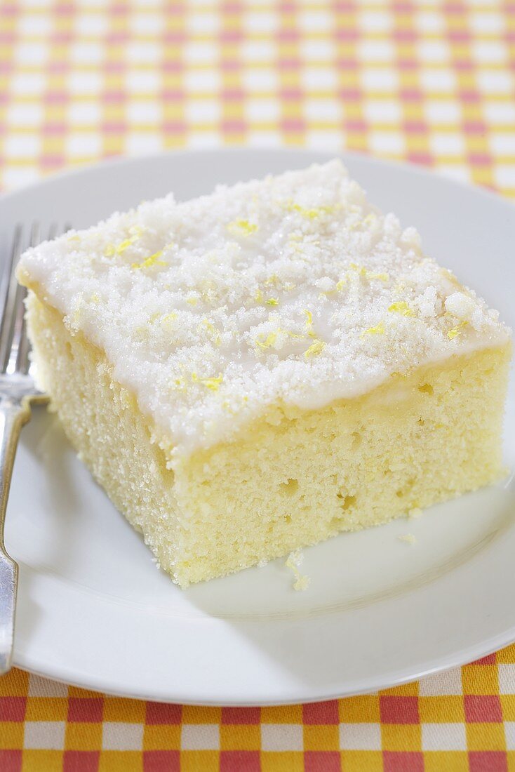 Piece of Lemon Buttermilk Sheet Cake on a White Dish
