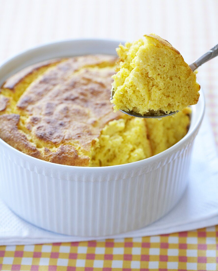 Corn Spoon Bread Being Spooned Out of Baking Dish