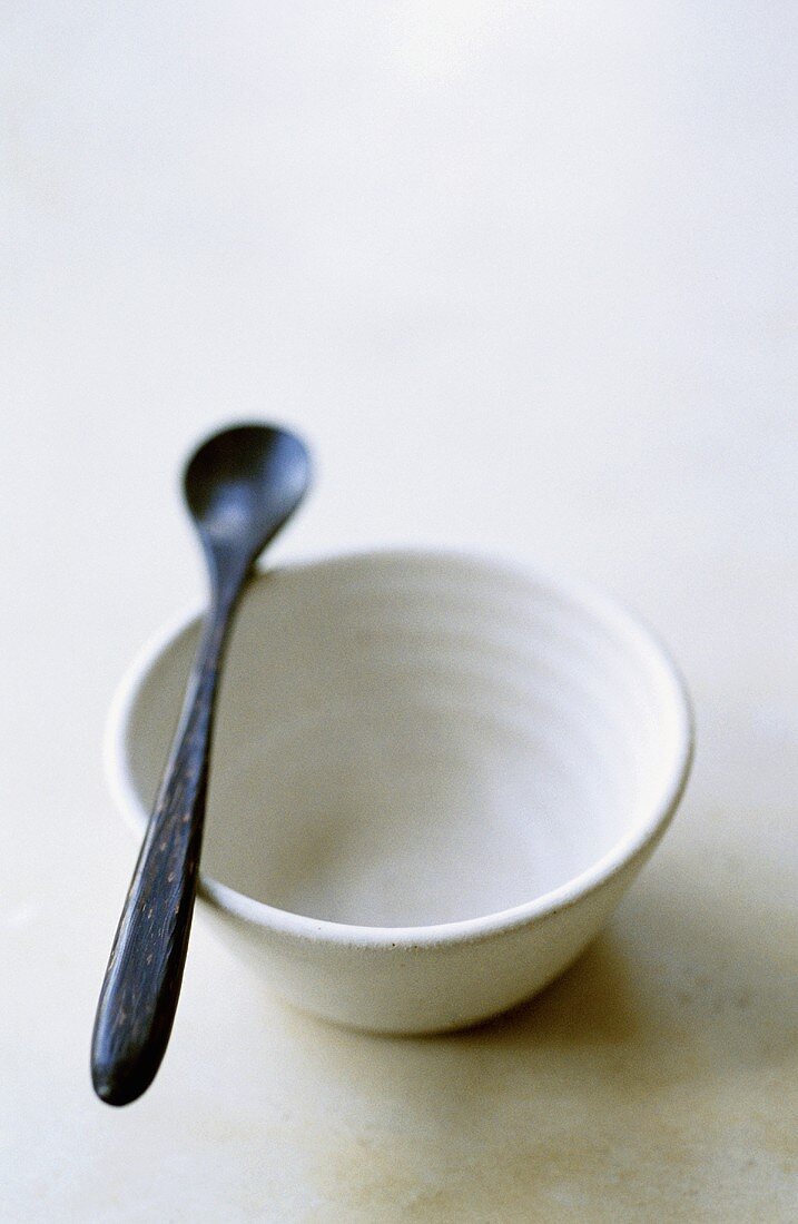 Empty White Bowl with Black Spoon