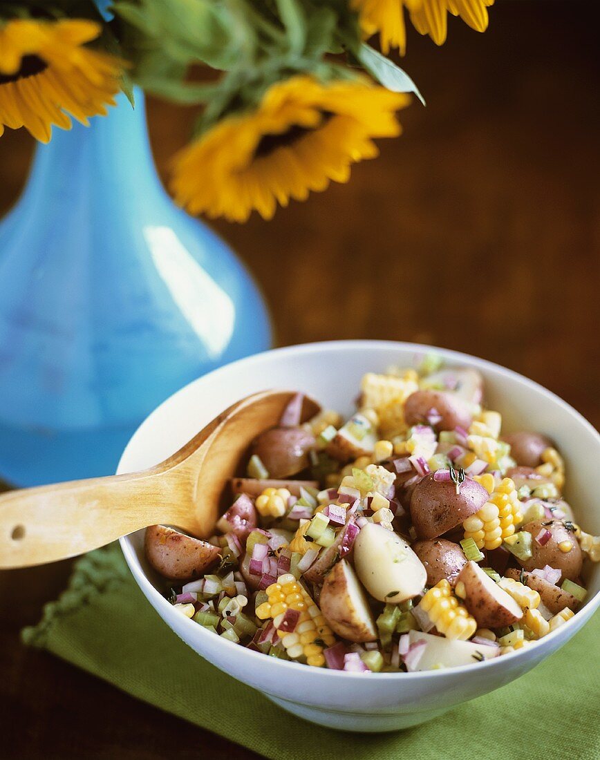 Sweet Corn Potato Salad in Serving Bowl with Wooden Spoon