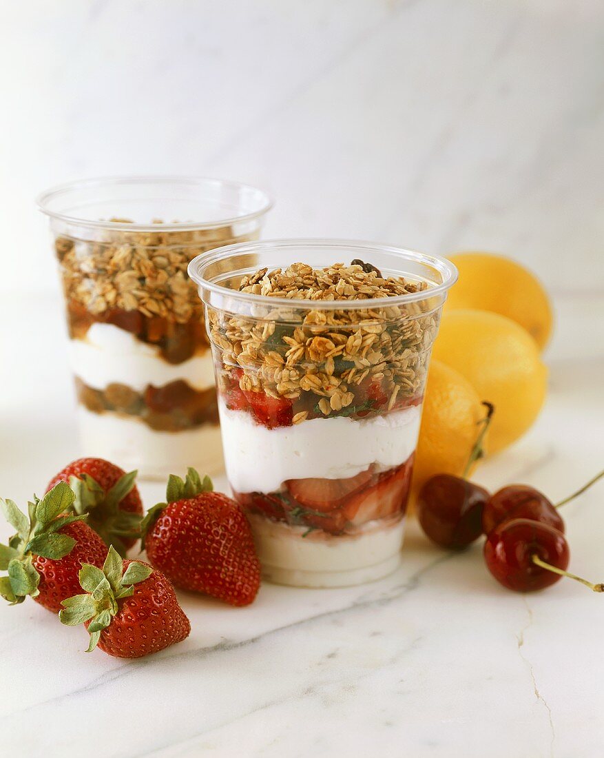 Joghurtparfaits mit Cerealien und Früchten in Plastikbechern