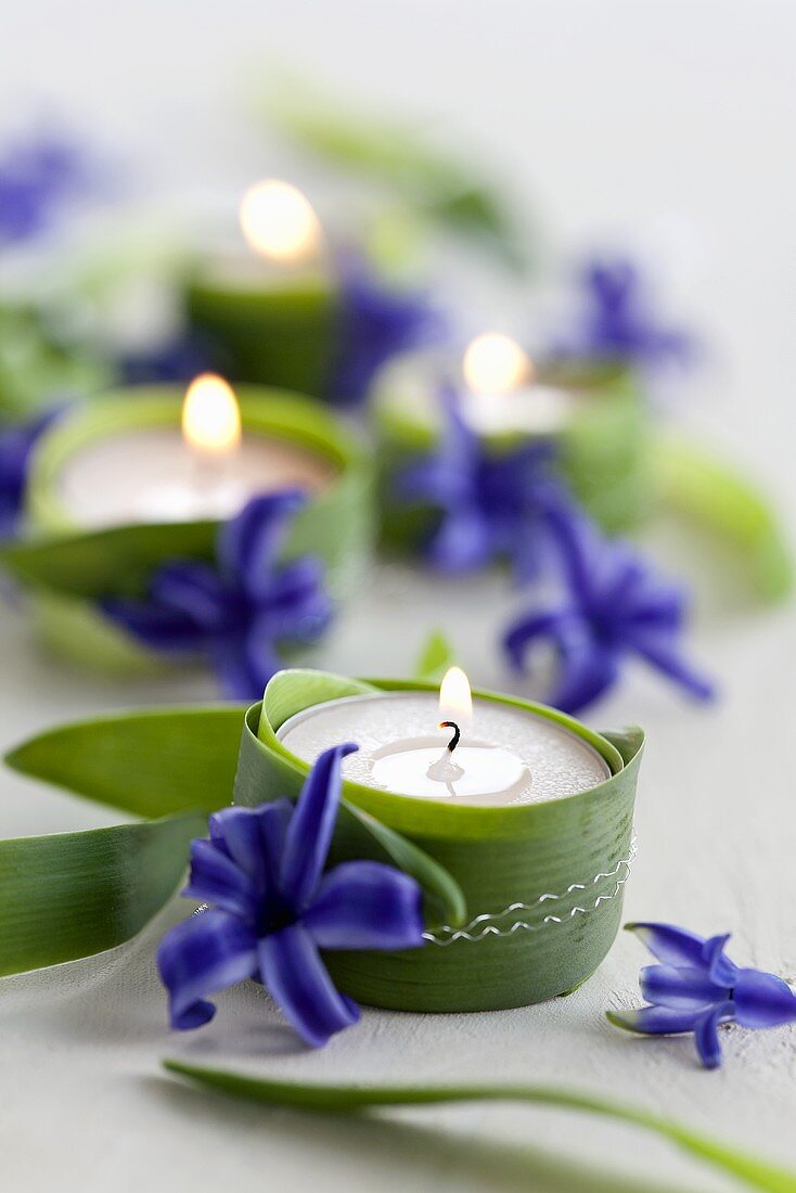 Tealights wrapped with leaves and decorated with hyacinth flowers