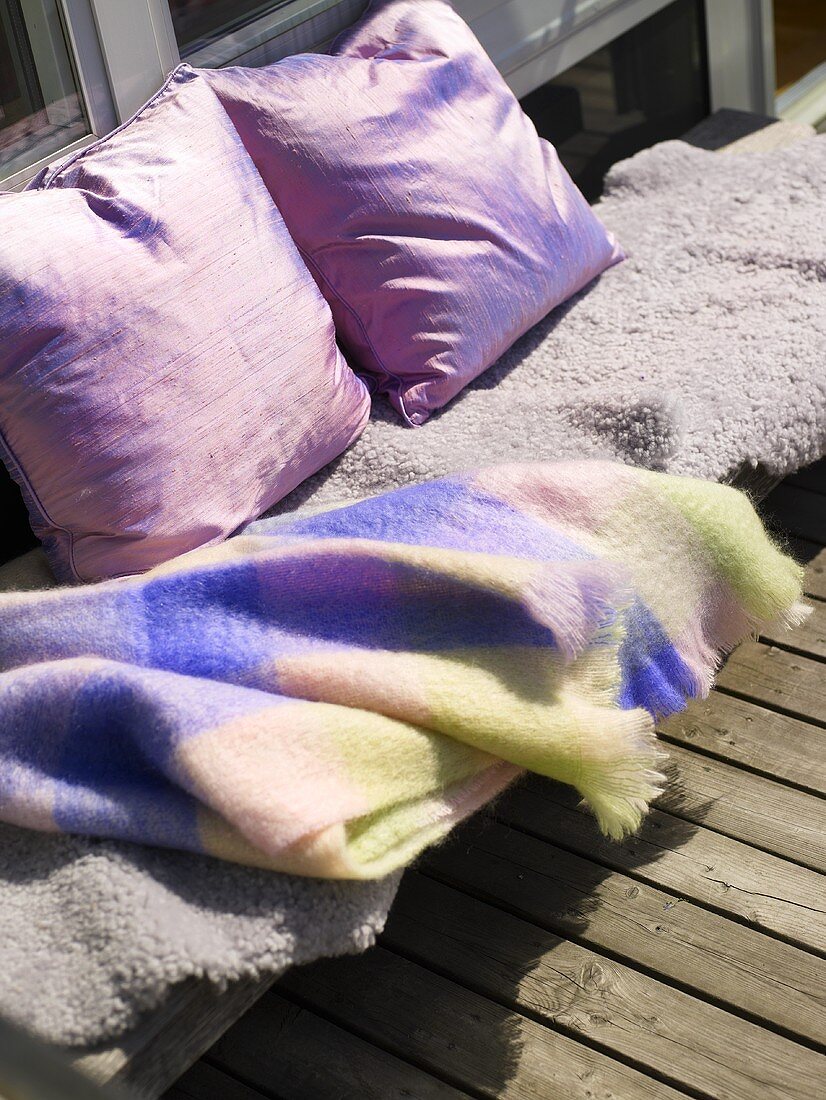Eine Decke und Kissen auf einem Balkon
