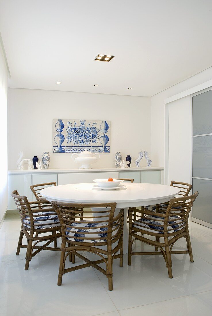 A round dining table and chairs in a dining room with an azulejo