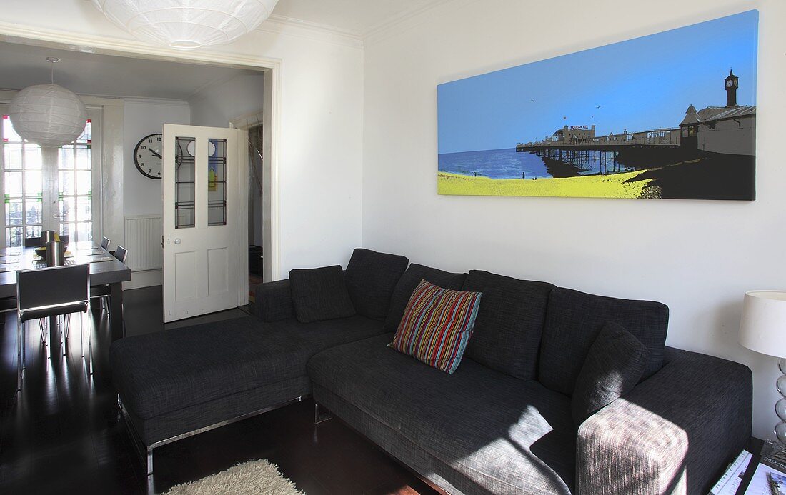 A large canvas picture above a black sofa