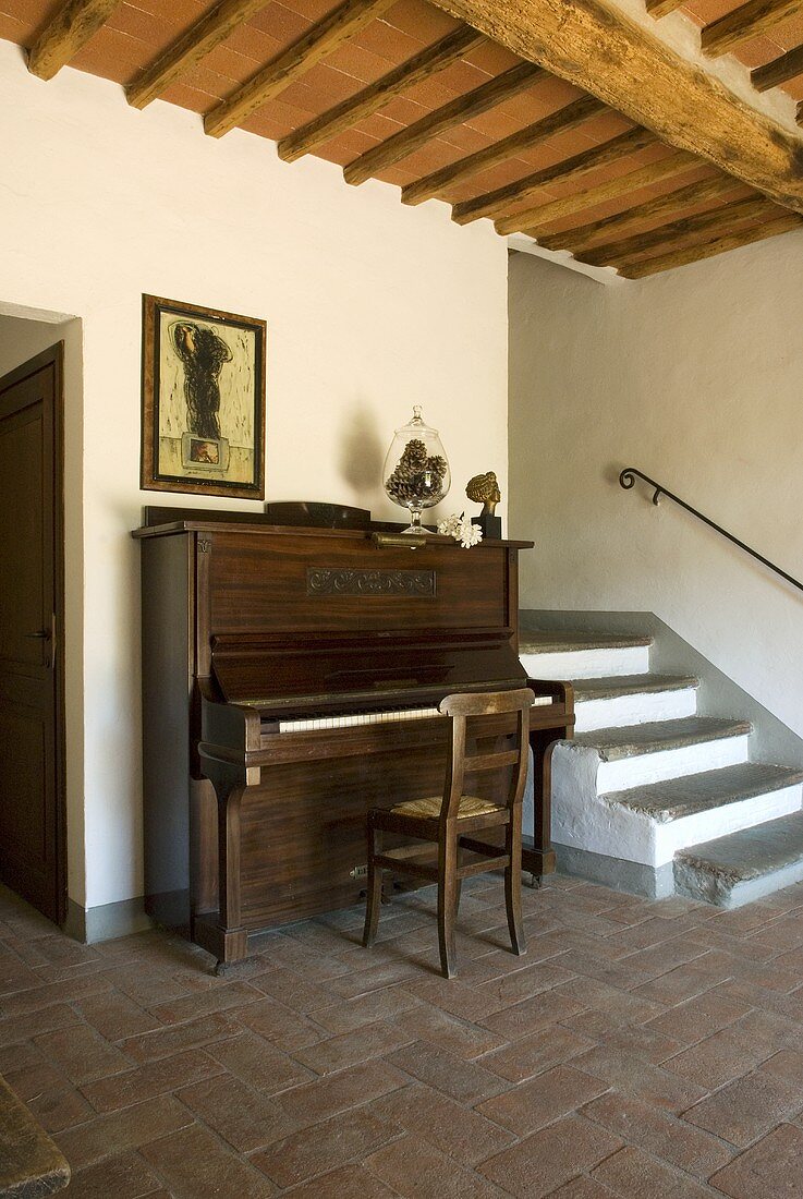 Ein Klavier neben der Treppe in einer Eingangshalle mit Terrakottaboden