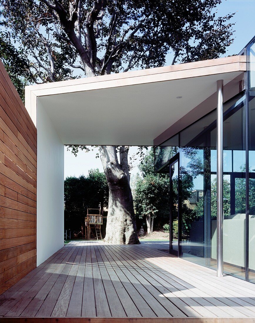 Covered walkway (terrace) with a view into a garden of a tree