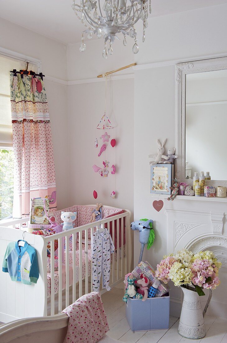 A white cot in a corner of a child's bedroom