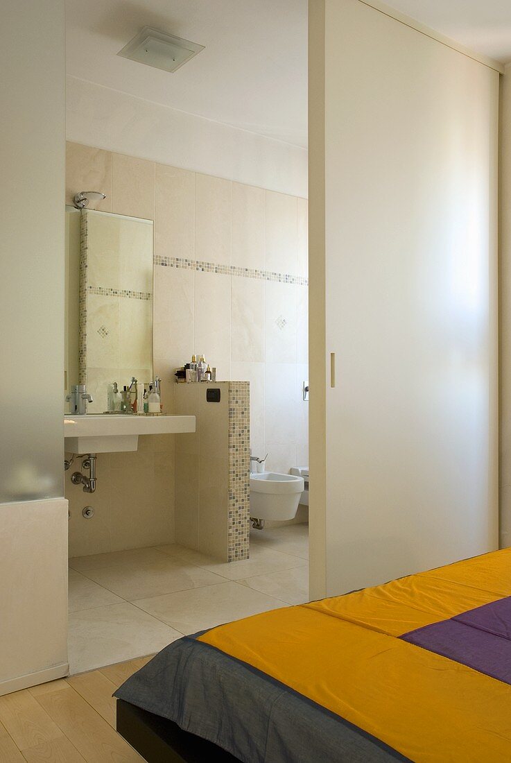 Bedroom with en suite bathroom - looking through an open sliding door at a washstand