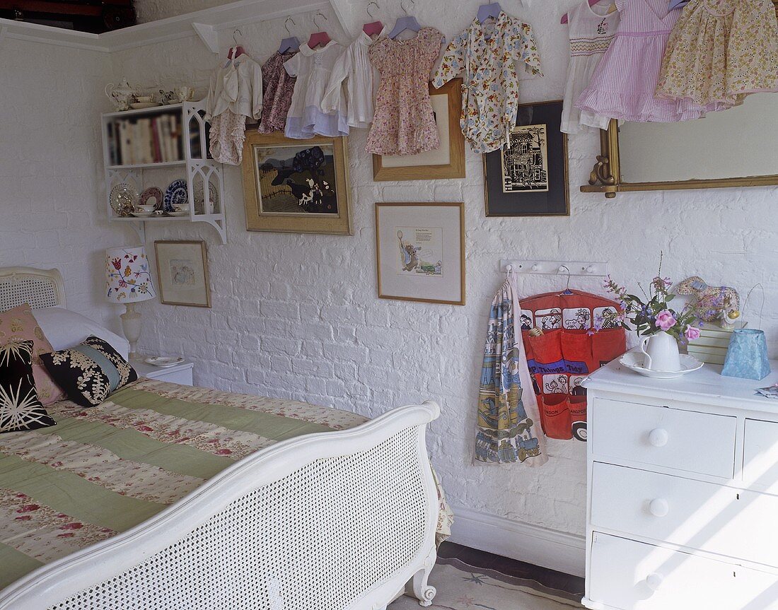 A bedroom in a country house with children's clothes hanging on the wall