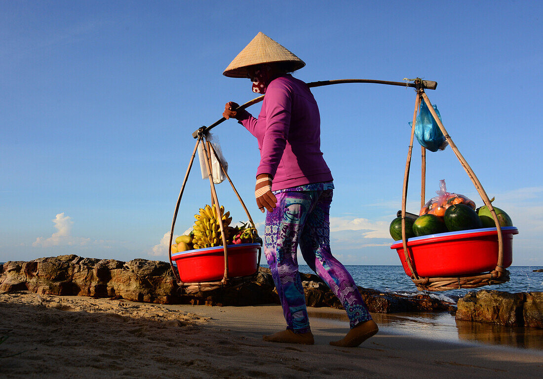 Woman carrying friut, Longbeach on the island of Phu Quoc, Vietnam, Asia