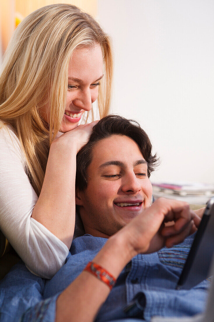 Young couple relaxing on the sofa, Playing on the tablet