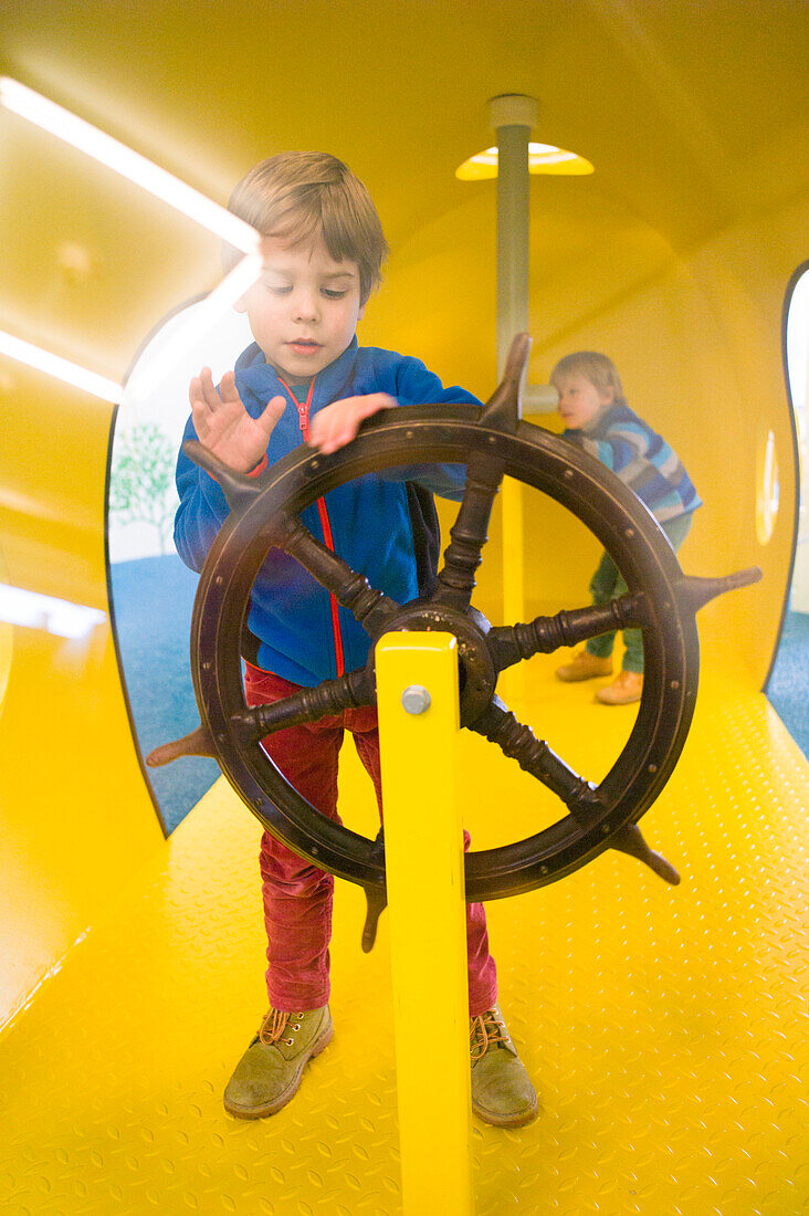 Boys playing in a submarine at the playground, Cuxhaven, North Sea, Lower Saxony, Germany