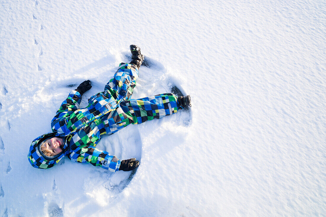 Junge spielt im Schnee, Cuxhaven, Nordsee, Niedersachsen, Deutschland