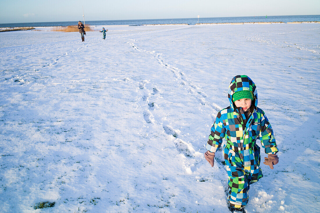 Junge geht im Schnee spazieren, Cuxhaven, Nordsee, Niedersachsen, Deutschland
