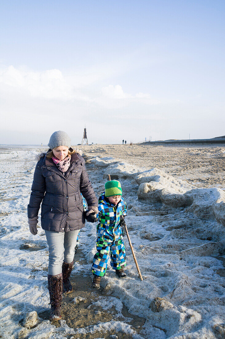 Young mother walking with her son on the beach, Cuxhaven, North Sea, Lower Saxony; Germany