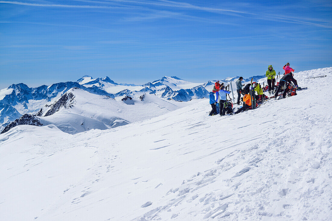 Mehrere Personen auf Skitour machen am Gipfel des Palon de la Mare Pause, Adamello im Hintergrund, Palon de la Mare, Val dei Forni, Ortlergruppe, Lombardei, Italien