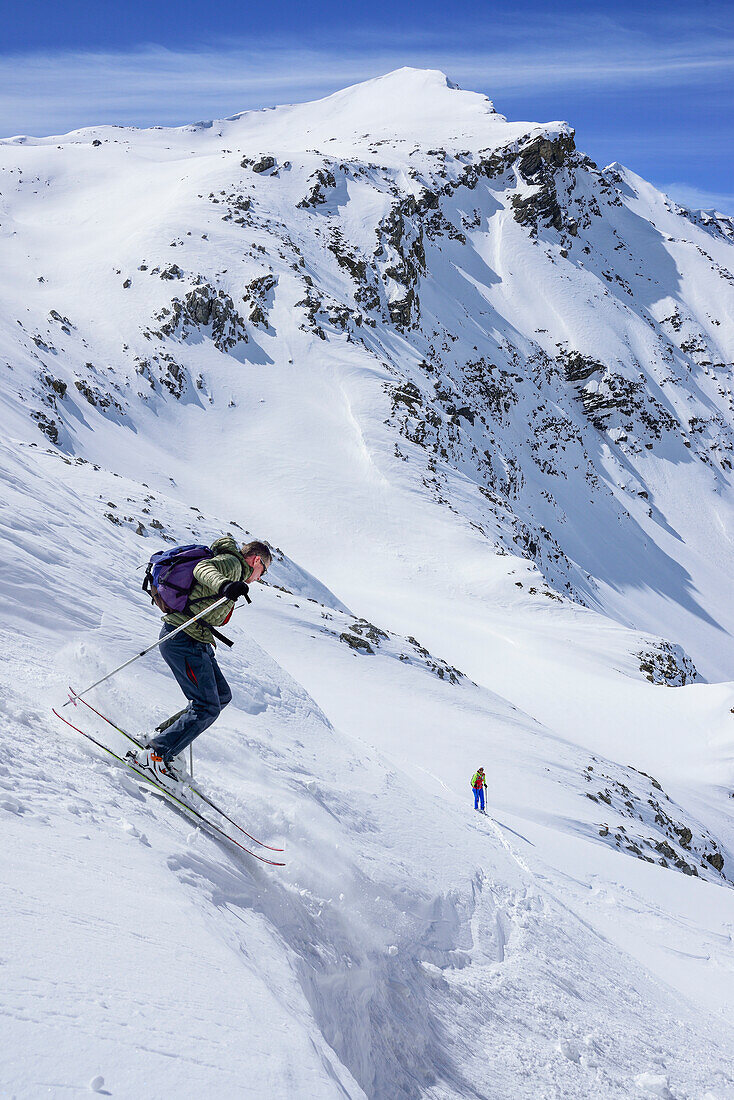 Man back-country skiing downhill from Piz Uter, Piz Uter, Livigno Alps, Engadin, Grisons, Switzerland