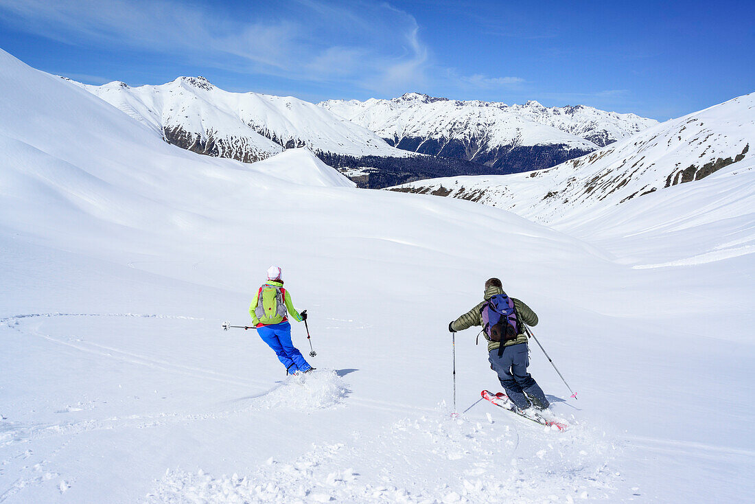 Two persons back-country skiing downhill from Piz Uter, Piz Uter, Livigno Alps, Engadin, Grisons, Switzerland