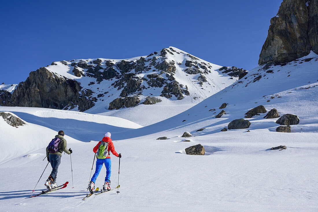 Two persons back-country skiing ascending towards Piz Lischana, Piz Lischana, Sesvenna Alps, Engadin, Grisons, Switzerland