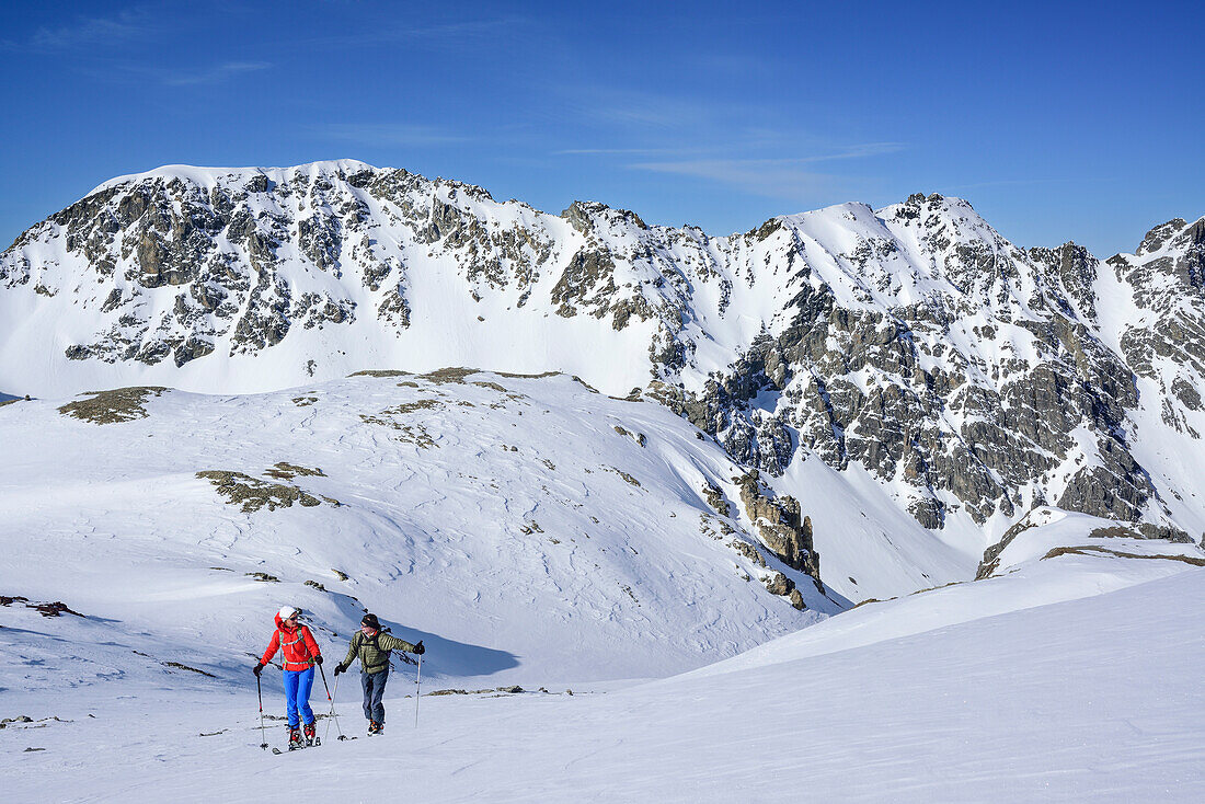 Zwei Personen auf Skitour steigen zum Piz Lischana auf, Piz Lischana, Sesvennagruppe, Engadin, Graubünden, Schweiz