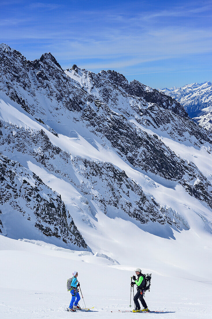 Two persons back-country skiing standing at glacier of Dreiherrnspitze, Dreiherrnspitze, valley of Ahrntal, Hohe Tauern range, South Tyrol, Italy