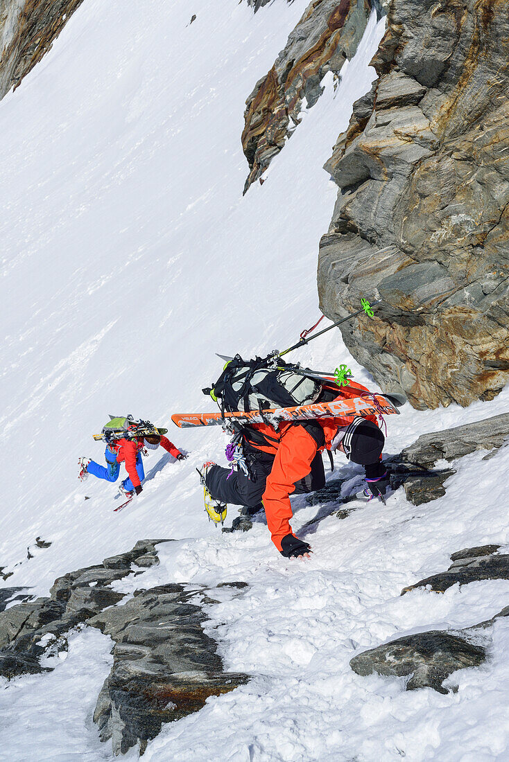 Zwei Personen auf Skitour steigen mit Pickel und Steigeisen von der Dreiherrnspitze ab, Dreiherrnspitze, Ahrntal, Hohe Tauern, Südtirol, Italien