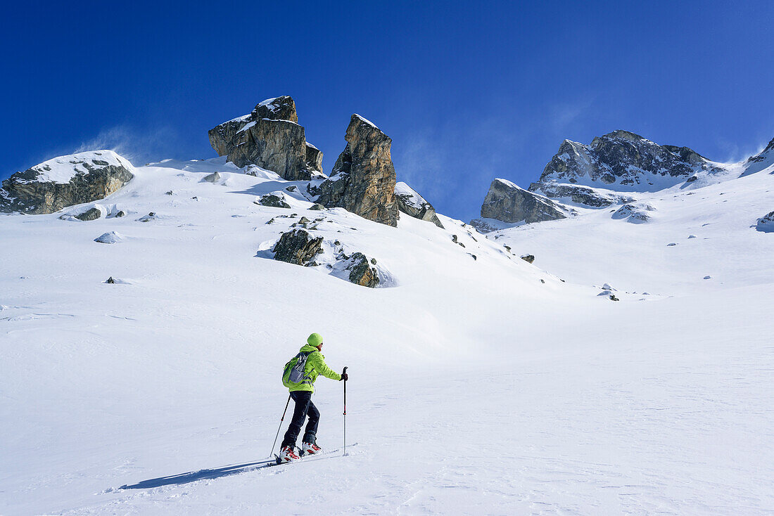 Frau auf Skitour steigt zum Colle di Vers auf, Rocca La Marchisa im Hintergrund, Colle di Vers, Valle Varaita, Cottische Alpen, Piemont, Italien