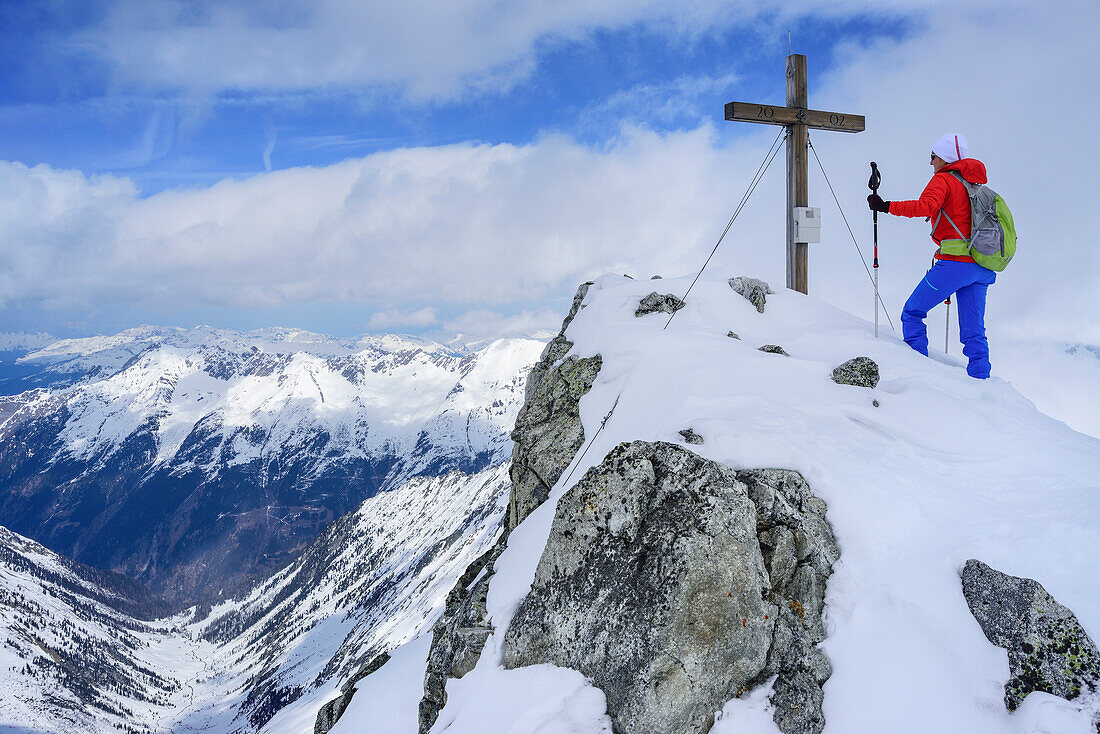 Woman back-country skiing standing on summit of Grundschartner, Grundschartner, Zillergrund, Zillertal Alps, Tyrol, Austria
