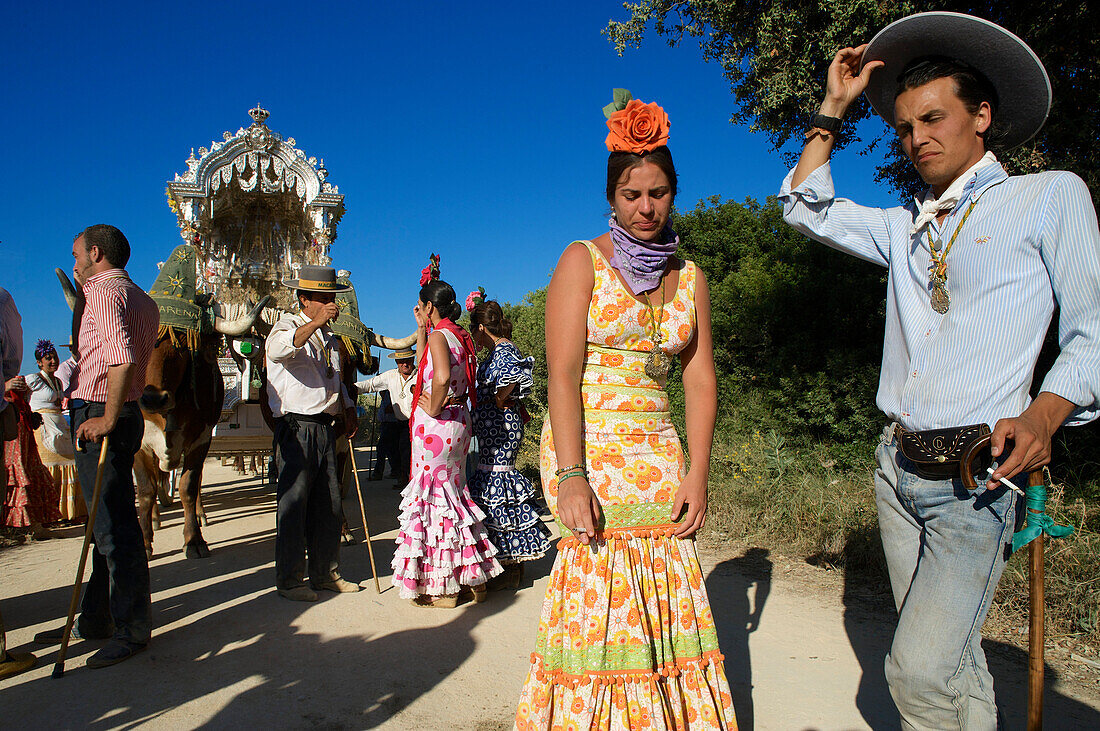 Pilger mit Ochsenkarren und Frauen in Flamencokleidern Wallfahrt zu Pfingsten zu 'Nuestra Senora de El Rocio' auf dem Pilgerweg La Raya Real von Sevilla nach El Rocio, Huelva, Andalusien, Spanien