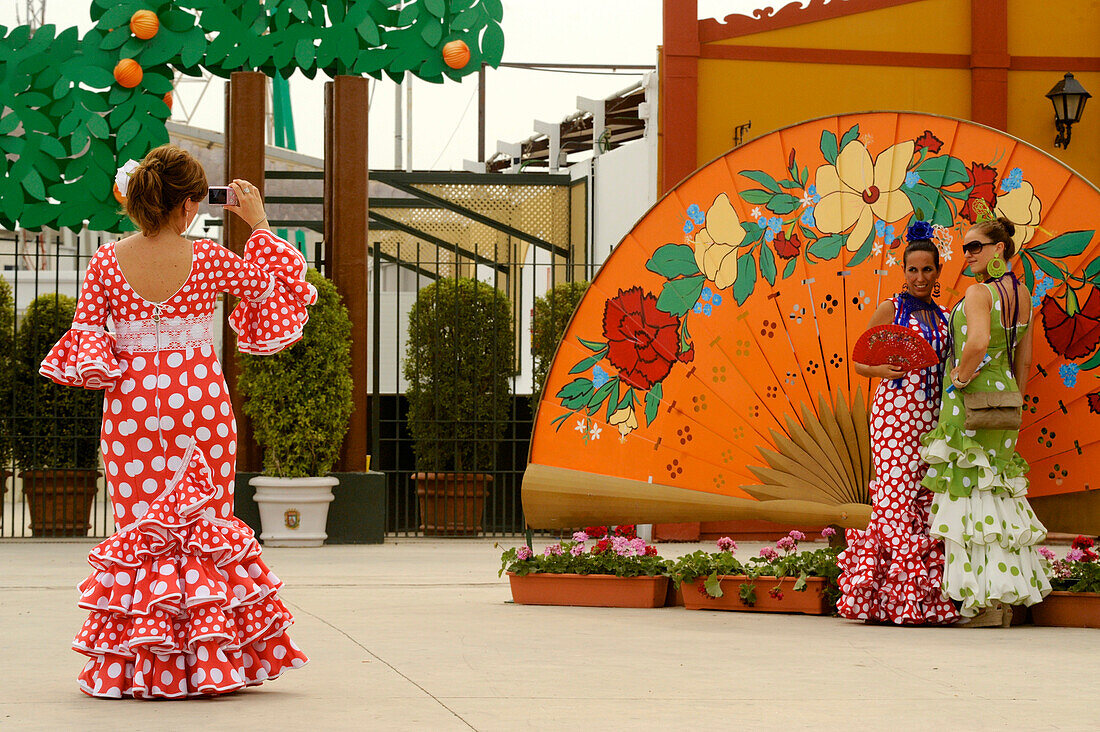 3 Frauen in Flamenco Kleidern auf der Feria, Malaga, Andalusien, Spanien