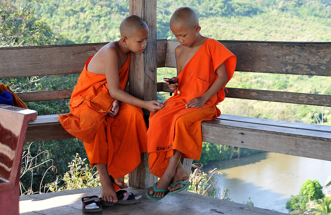 Two small Buddhist novice monks at Wat Thaton over the river Mae Kok, North-Thailand, Thailand