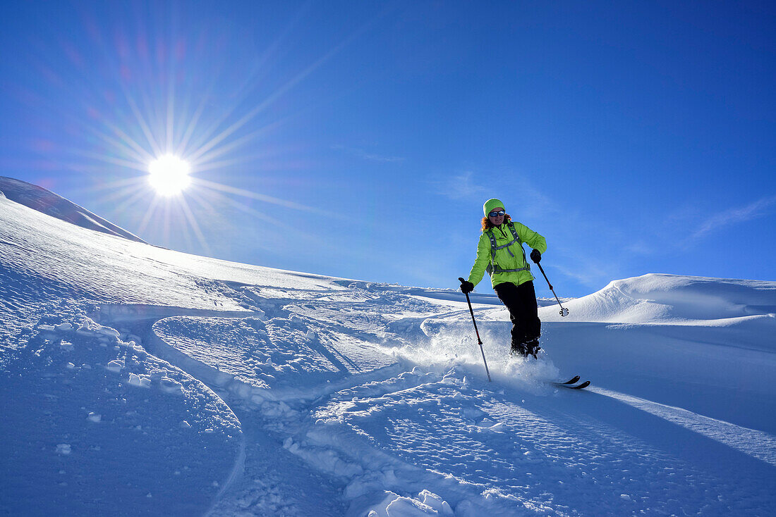 Frau auf Skitour fährt durch Pulverschnee ab, Munt Buffalora, Ofenpass, Sesvennagruppe, Engadin, Graubünden, Schweiz