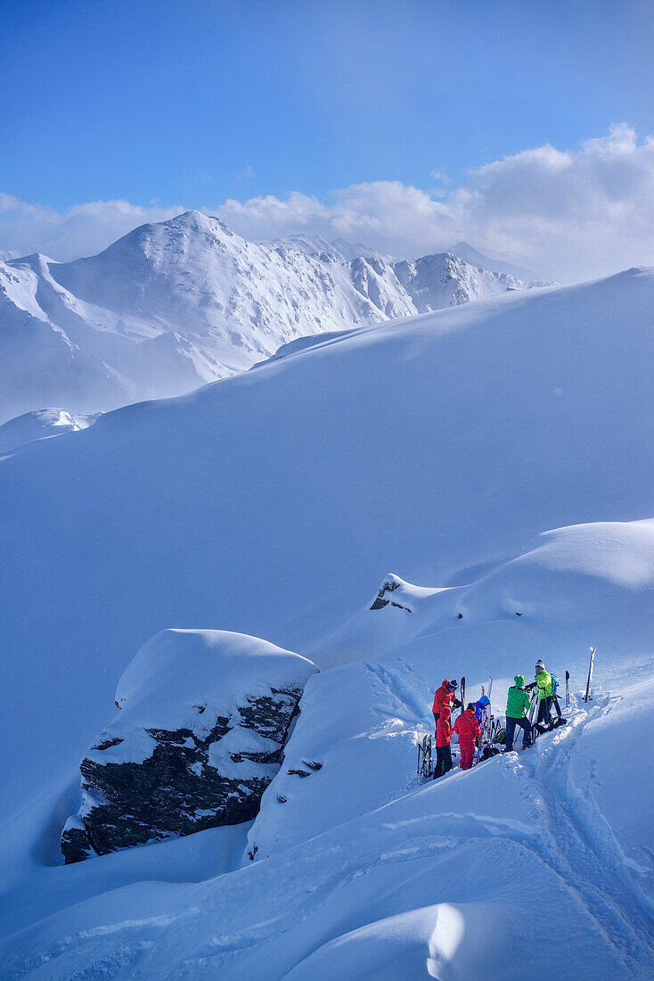 Group of persons back-country skiing having a break, Pallspitze, Langer Grund, Kitzbuehel range, Tyrol, Austria