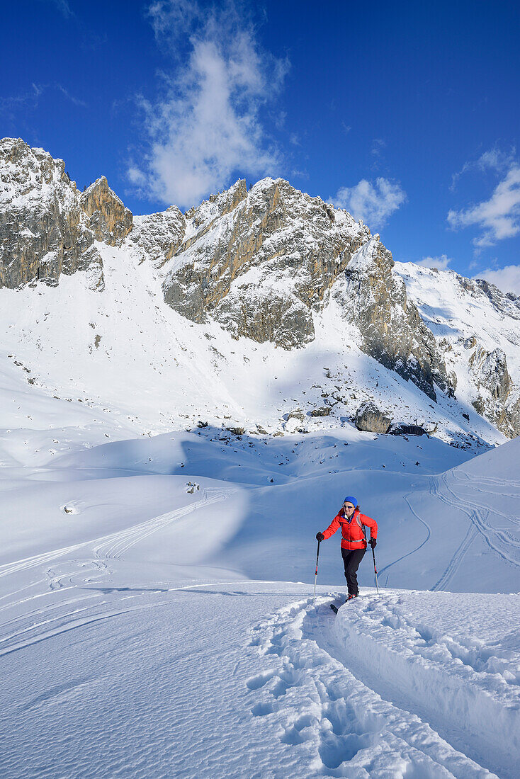 Woman back-country skiing ascending towards Monte Soubeyran, Monte Soubeyran, Valle Maira, Cottian Alps, Piedmont, Italy