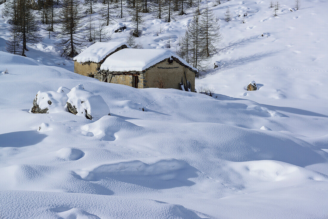 Snow-covered alpine huts at Valle Enchiausa, Valle Enchiausa, Valle Maira, Cottian Alps, Piedmont, Italys