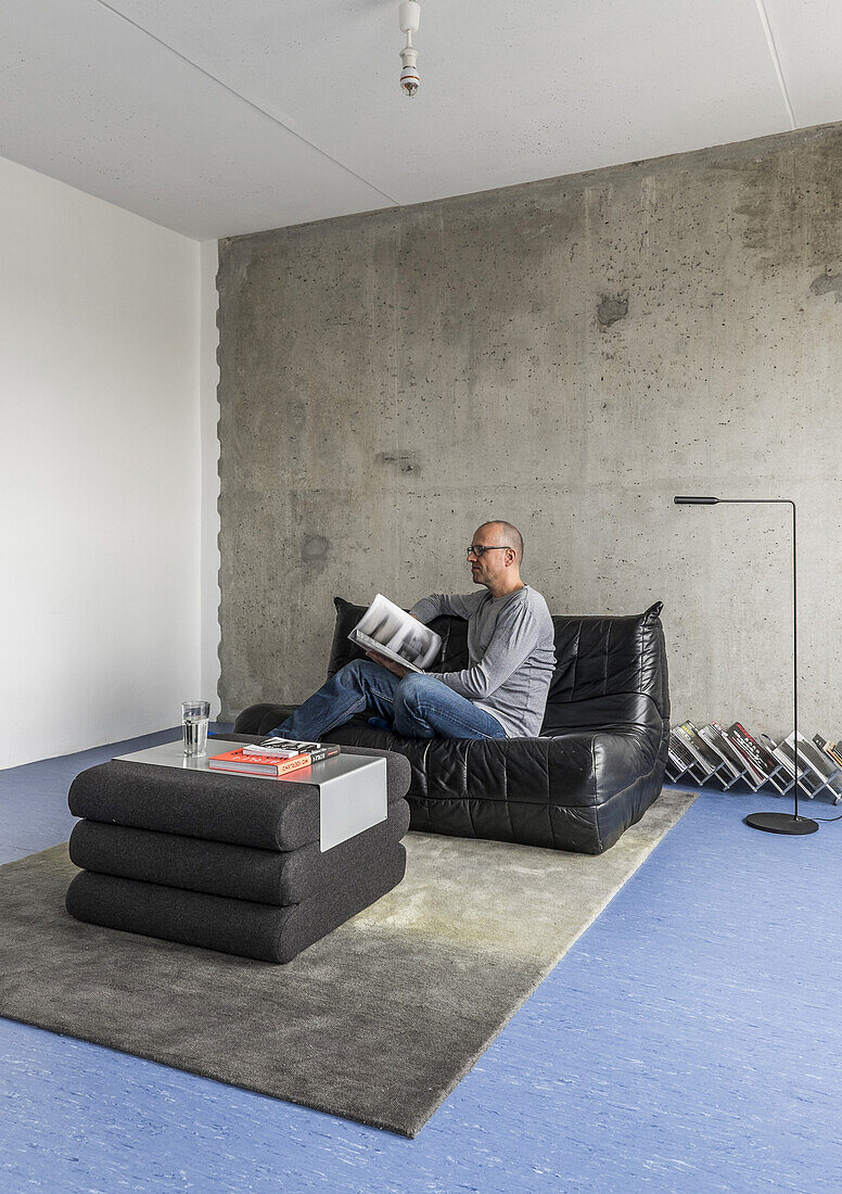 Mann in einer modernisierte Plattenbauwohnung am Alexanderplatz, Berlin, Deutschland