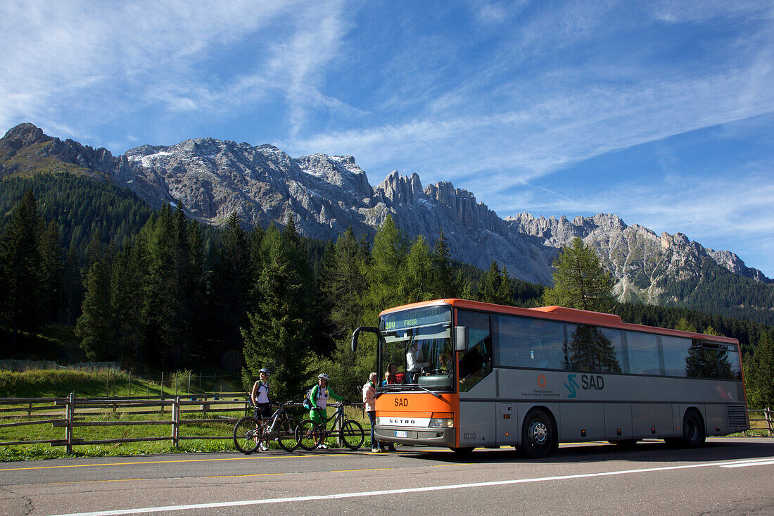 two mountain bikers waiting for a public service bus, Trentino Italy
