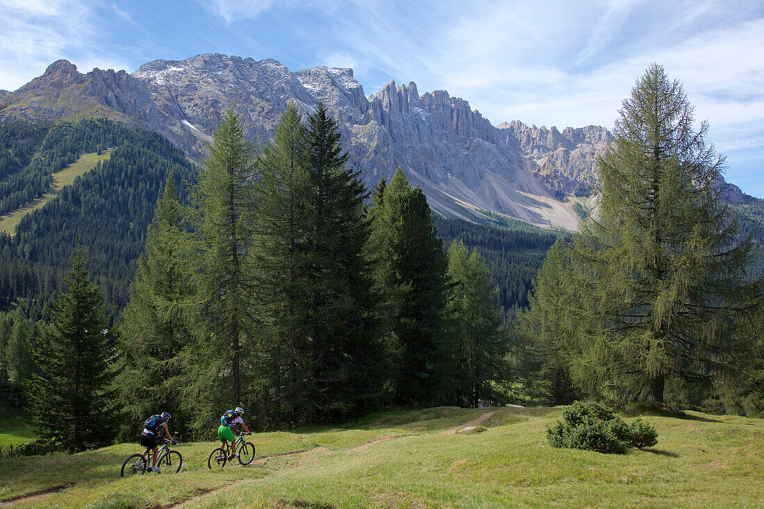 two mountain bikers on a single-trail, Trentino Italy