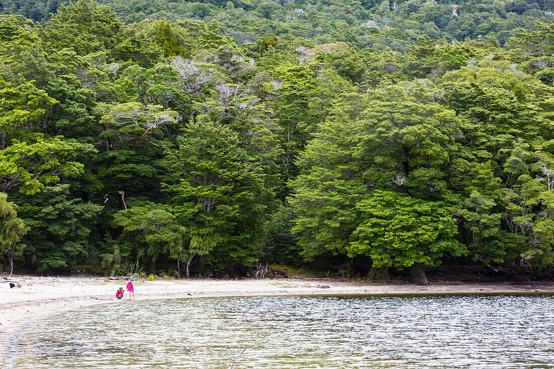 Two girls playing at Lake Manapouri, Hope Arm Bay, Fjordland, South Island, New Zealand