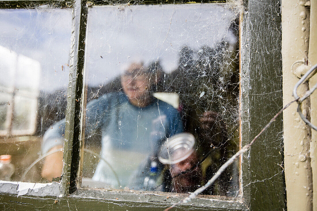 A women cooking in a shabby Hut, Fjordland, Lake Manapouri, South Island, New Zealand