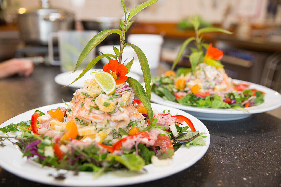 Vera und Reto Balzer bei der Zubereitung von Anatoki Lachs, Sans Souci Inn des Schweizer Ehepaars Vera und Reto Balzer, Pohara, Golden Bay, South Island, Neuseeland