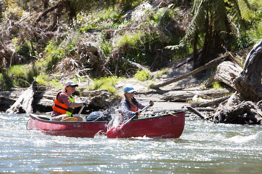 A girl and a woman on a canoe trip on the Whanganui River, North Island, New Zealand