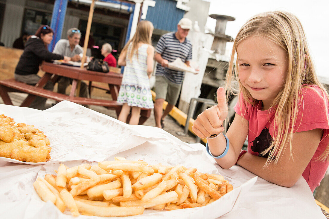 A girl with fish and chips at Tauranga, North Island, New Zealand