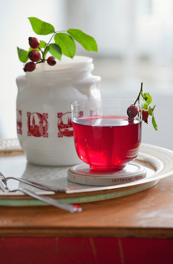 Rosehip tea and a rosehip sprig in a jar