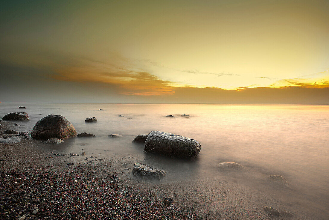 Große, abgeschliffene Stein am Kiesstrand an der Ostsee in der Abendstimmung, Wustrow, Darß, Mecklenburg Pommern, Deutschland