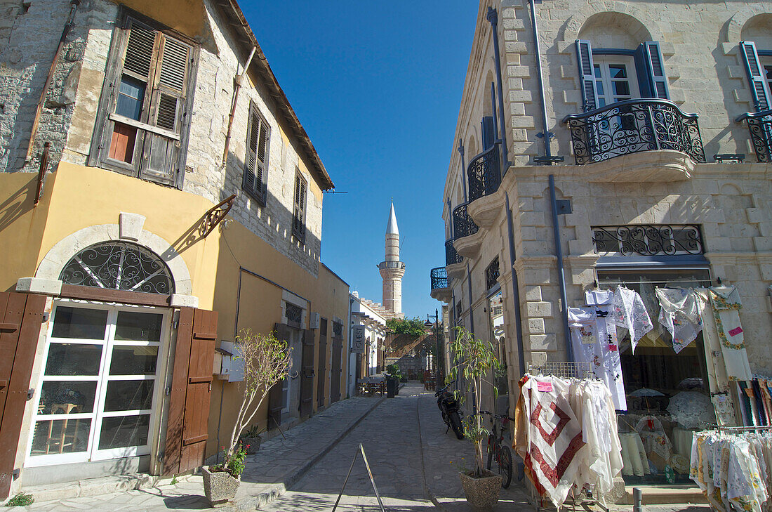 Blick auf Minarett und Gasse mit Geschäft für Tücher in Limassol, Limassol District, Zypern