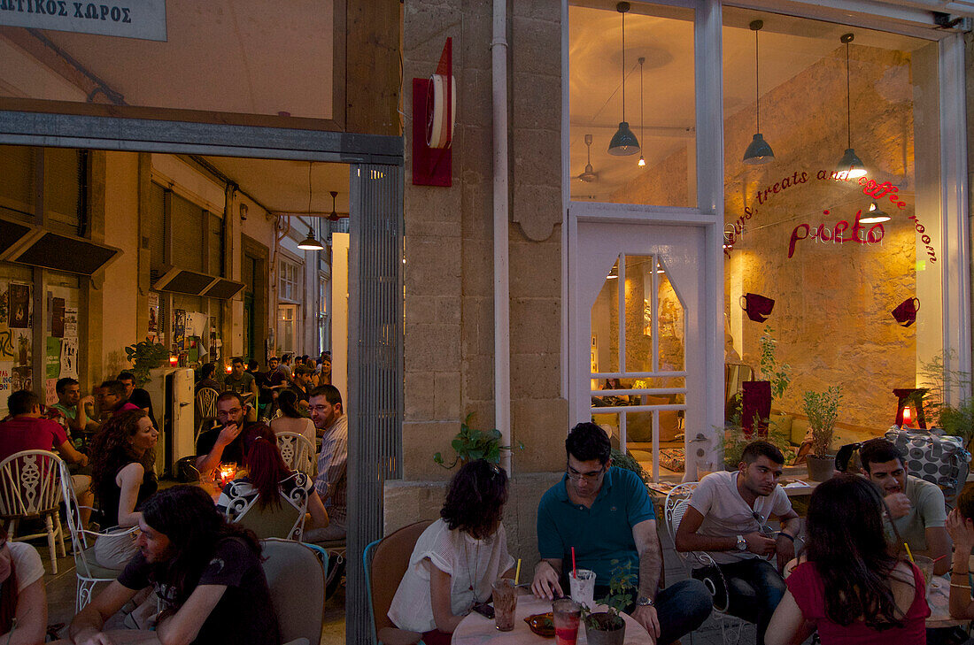 Viele Menschen sitzen am Abend in Tischen im Café Pieto in einem Durchgang in Leika Gaitonia in der  Altstadt Lefkosia, Nicosia, Zypern