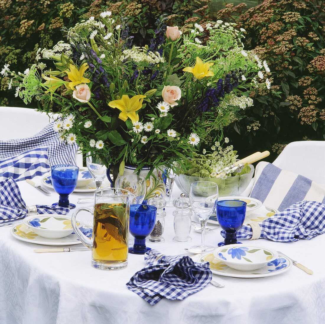 Sommerlicher Blumenstrauss auf weiss-blau gedecktem Tisch